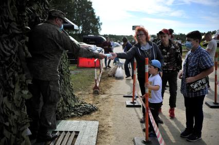 Екатеринбург. Танковый полигон 32-го военного городка. Международный военно-технический форум \'Армия-2020\'. Военнослужащий выдает медицинские маски посетителям форума