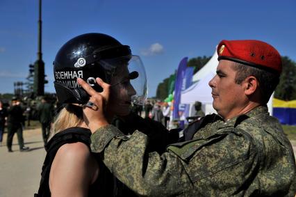 Екатеринбург. Танковый полигон 32-го военного городка. Международный военно-технический форум \'Армия-2020\'. Девушка примеряет бронежилет и шлем военной полиции