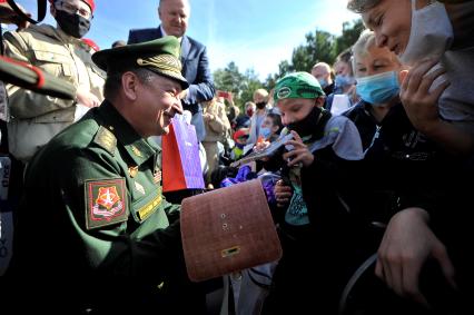 Екатеринбург. Танковый полигон 32-го военного городка. Международный военно-технический форум \'Армия-2020\'. Командующий восками ЦВО генерал-лейтенант Александр Лапин вручает подарки детям-инвалидам после церемонии открытия форума