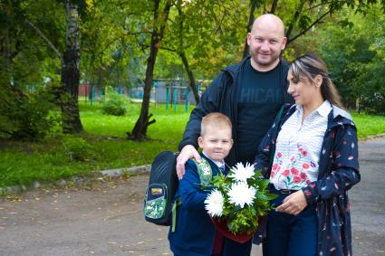Новосибирск.   Родители провожают первоклассника в школу в День знаний.