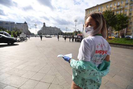 Москва.  Девушка-волонтер раздает листовки у мобильного пункта вакцинации на Пушкинской площади.