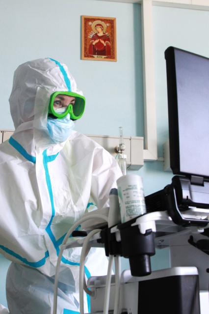 Иркутск. Городская клиническая больница №1. Врач обследует пациента в отделении для зараженных коронавирусной инфекцией COVID-19.