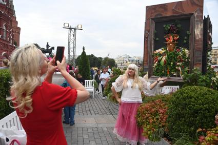 Москва.   Женщина фотографируется во время посещения арт-объекта `Тропа ботанического сада`, расположенного между Манежной площадью и площадью Революции, на праздничных гуляниях в День города.