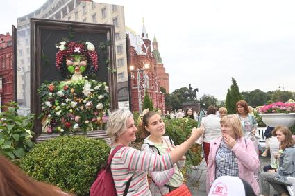 Москва.   Женщины фотографируются во время посещения арт-объекта `Тропа ботанического сада`, расположенного между Манежной площадью и площадью Революции, на праздничных гуляниях в День города.