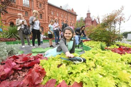 Москва.  Девочка  во время посещения арт-объекта `Тропа ботанического сада`, расположенного между Манежной площадью и площадью Революции, на праздничных гуляниях в День города.