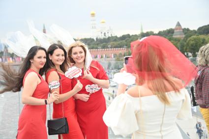 Москва. Девушки фотографируются на  Парящем мосту парка Зарядье  во время праздничных гуляний  в День города.