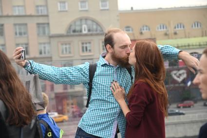 Москва. Молодые люди фотографируются на  Парящем мосту парка Зарядье  во время праздничных гуляний  в День города.