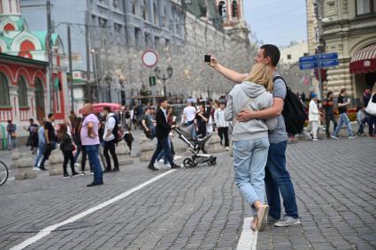 Москва.  Молодые люди фотографируются на Никольской улице во время праздничных гуляний  в День города.