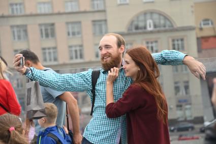 Москва. Молодые люди фотографируются на  Парящем мосту парка Зарядье  во время праздничных гуляний  в День города.