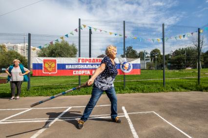 Москва. Женщина  во время игры в городки  на одной из площадок  города.