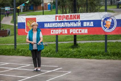 Москва. Женщина во время игры в городки на одной из площадок города.