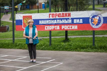 Москва. Женщина  во время игры в городки  на одной из площадок  города.