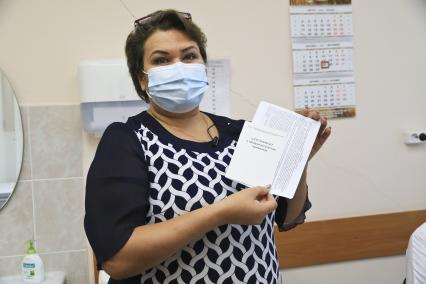 Баранул. Женщина демонстрирует сертификат и согласие на прививку комбинированной векторной вакцины для профилактики коронавирусной инфекции Гам-Ковид-Вак. Вакцина произведена в НИЦЭМ им Н.Ф.Гамалеи.