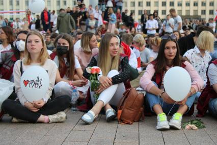 Минск. Протестующие сидят на асфальте во время митинга против результатов выборов президента Белоруссии на площади Независимости, где расположены здания правительства и ЦИК.