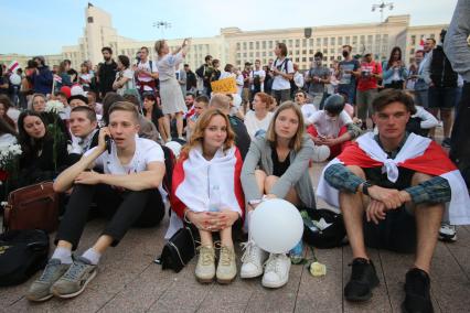 Минск. Протестующие сидят на асфальте во время митинга против результатов выборов президента Белоруссии на площади Независимости, где расположены здания правительства и ЦИК.