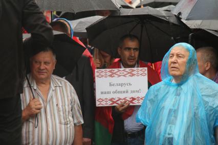 Минск. Мужчина держит плакат `Беларусь - наш общий дом!` во время митинга в поддержку президента Белоруссии Александра Лукашенко.