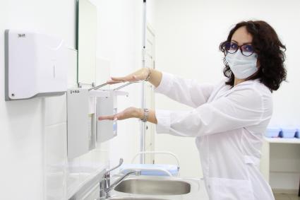 Иркутск. Сотрудница лаборатории обрабатывает руки санитайзером.