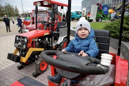 Минск. Мальчик сидит за рулем трактора на XXX Международной сельскохозяйственной выставке `Белагро-2020` на Футбольном манеже.