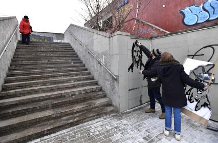 Москва. Уличный художник из проекта `После иконы` Антон Беликов вместе с командой наносит на стену граффити `Покайтесь` с помощью трафарета.