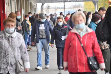 Москва. Пассажиры пригородных поездов в медицинских масках на платформе.