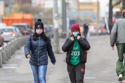 Москва.  Женщины в защитной маске на улице.