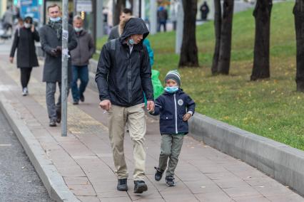 Москва.  Прохожие в защитной маске на улице.