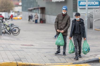 Москва.  Мужчины в защитной маске на улице.