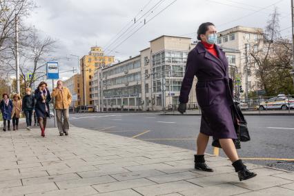 Москва.  Женщина в защитной маске на улице.