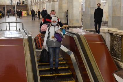 Москва. Пассажиры в медицинских масках на эскалаторе метро.