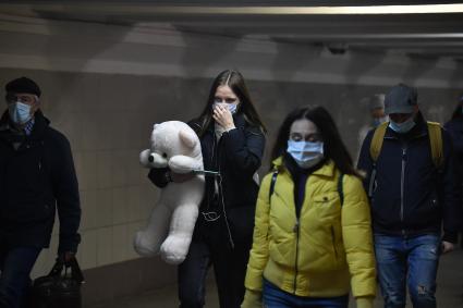 Москва. Люди в медицинских масках в подземном переходе метро.