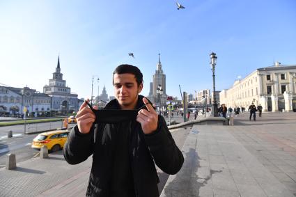 Москва. Мужчина с защитной маской в руках.