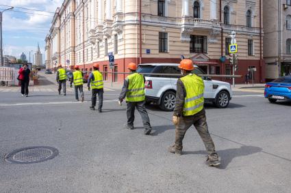 Москва. Рабочие несут трубу.