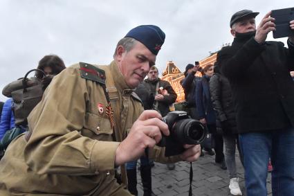 Москва. Мужчин в военной форме времен ВОВ фотографирует на  Красной площади  в День народного единства.