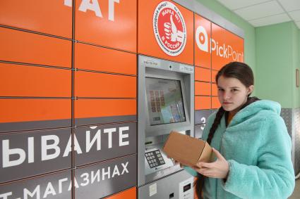 Москва. Девушка получает  заказа через постамат PickPoint.