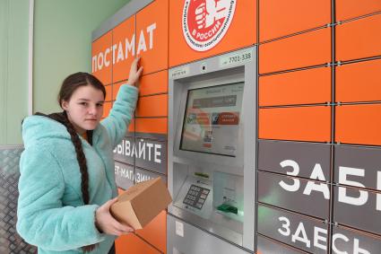 Москва. Девушка получает  заказа через постамат PickPoint.
