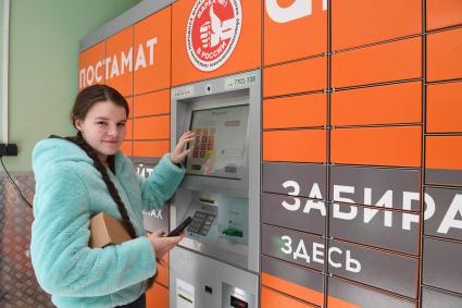 Москва. Девушка получает  заказа через постамат PickPoint.