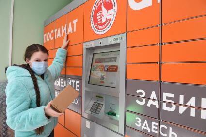 Москва. Девушка получает  заказа через постамат PickPoint.