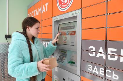 Москва. Девушка получает  заказа через постамат PickPoint.
