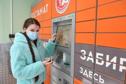 Москва. Девушка получает  заказа через постамат PickPoint.
