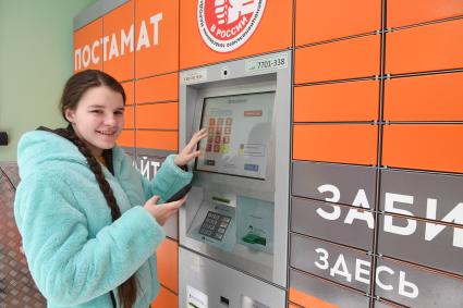 Москва. Девушка получает  заказа через постамат PickPoint.