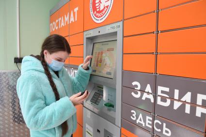 Москва. Девушка получает  заказа через постамат PickPoint.