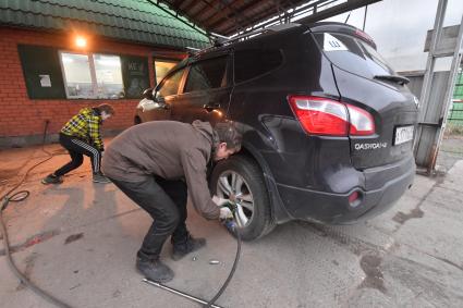 Москва.  Замена колес автомобиля в шиномонтажной мастерской.