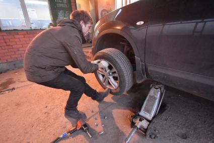 Москва.  Замена колес автомобиля в шиномонтажной мастерской.