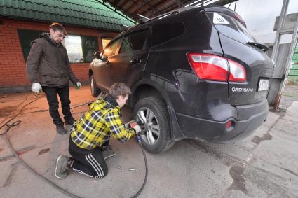 Москва.  Замена колес автомобиля в шиномонтажной мастерской.