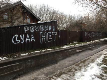 Москва. п.Речник. Надпись на заборе частного дома `Решения суда нет!`.