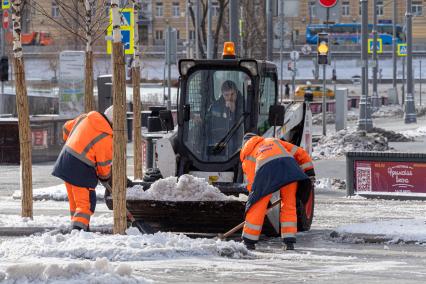 Москва. Сотрудники коммунальной службы во время уборки снега  на одной из улиц города.