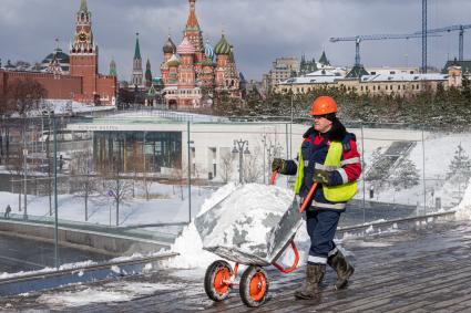 Москва. Сотрудник коммунальной службы во время уборки снега на `парящем` мосту  в парке `Зарядье`.