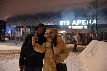 Москва.  Мужчина с женщиной фотографируются на фоне `ВТБ Арена - Центральный стадион `Динамо` имени Льва Яшина`.