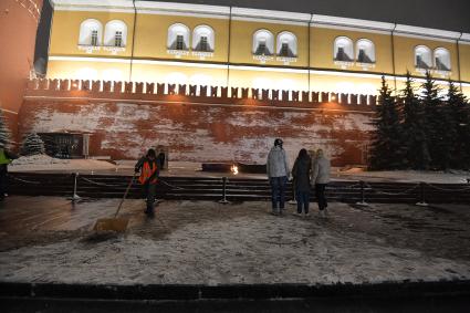 Москва.  Уборка снега у Вечного огня во время снегопада в Александровском саду.