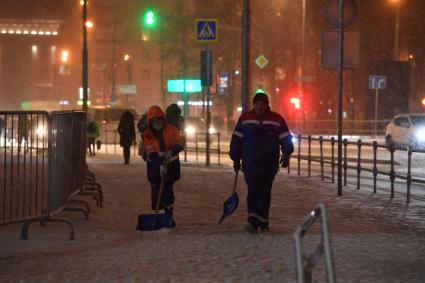 Москва. Дворники чистят снег на одной из улиц города во время снегопада.